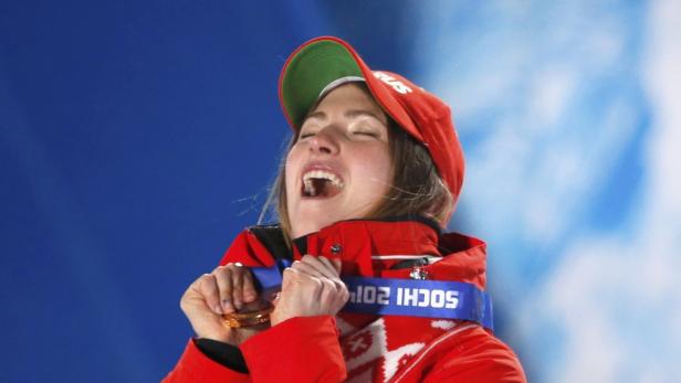 Eine jubelnde Sportlerin mit Goldmedaille bei den Olympischen Winterspielen in Sotschi 2014.