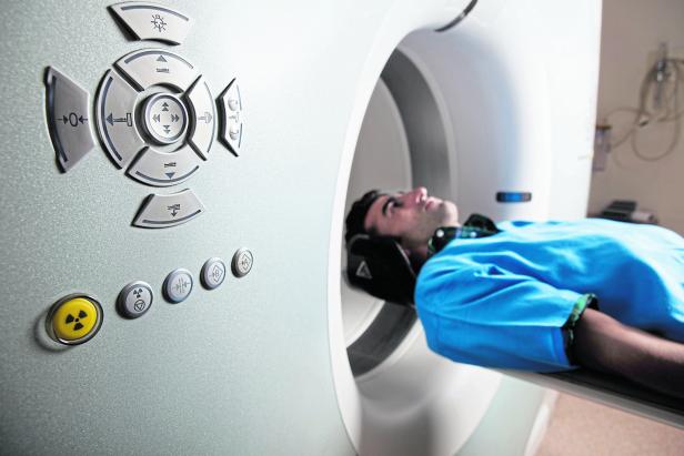 Man having a medical examination via modern CT scanner