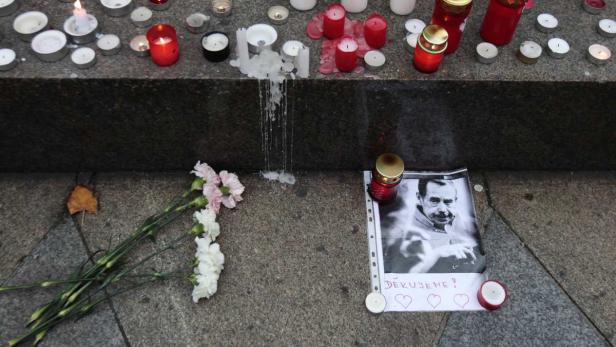 Kerzen, Blumen und ein Porträt von Václav Havel auf dem Bürgersteig.
