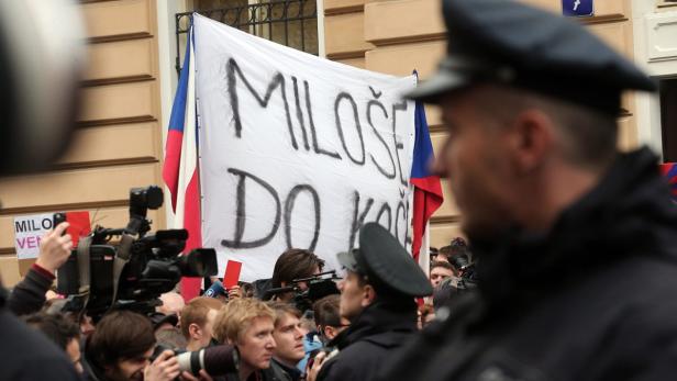 Demonstranten halten ein Transparent mit der Aufschrift „Miloše do koše“ (Milos in den Müll).