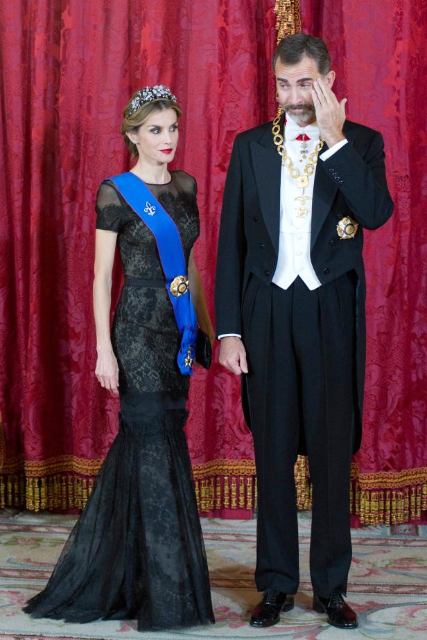 König Felipe VI. und Königin Letizia von Spanien posieren vor einem roten Vorhang.