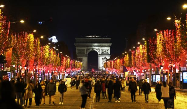 Die Champs-Élysées in Paris mit dem Arc de Triomphe im Hintergrund, beleuchtet für die Weihnachtszeit.