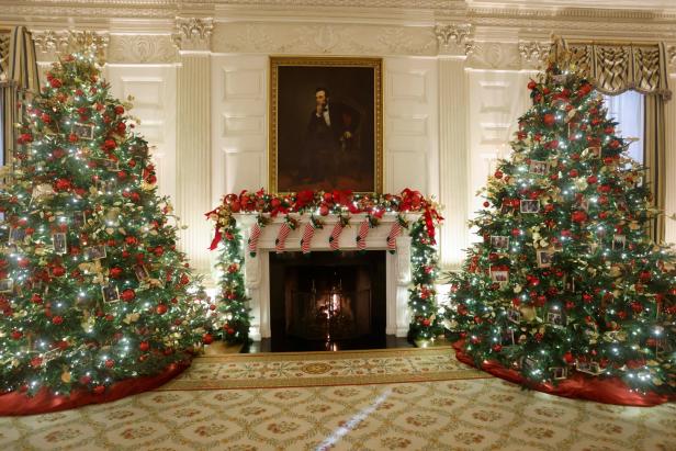 Der Raum ist weihnachtlich geschmückt mit zwei großen Tannenbäumen und einem Porträt von Abraham Lincoln über dem Kamin.