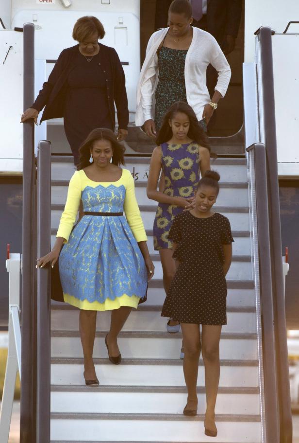 Michelle Obama und ihre Familie steigen eine Flugzeugtreppe hinunter.