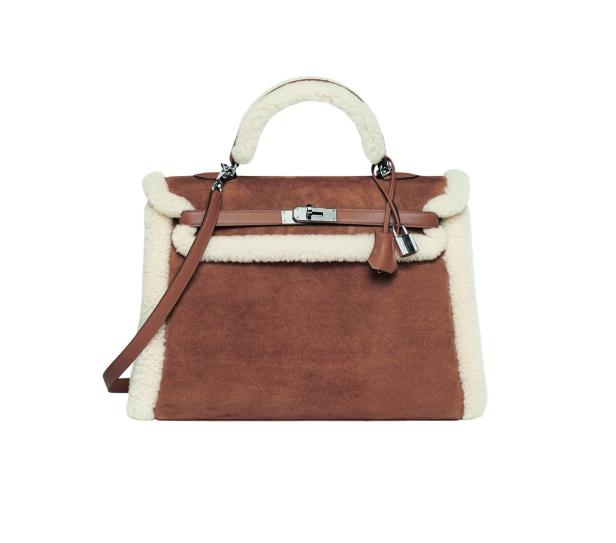 Eine braune Handtasche mit weißem Shearling-Besatz und silbernem Verschluss.