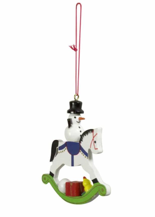 Ein hölzerner Christbaumschmuck in Form eines Schaukelpferds mit einem Schneemann darauf.