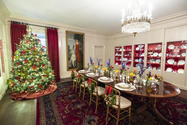 Ein festlich geschmücktes Esszimmer mit Weihnachtsbaum und gedecktem Tisch.