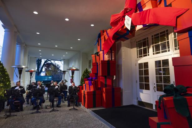 Ein Bläserensemble spielt vor dem mit übergroßen Geschenken geschmückten Weißen Haus.