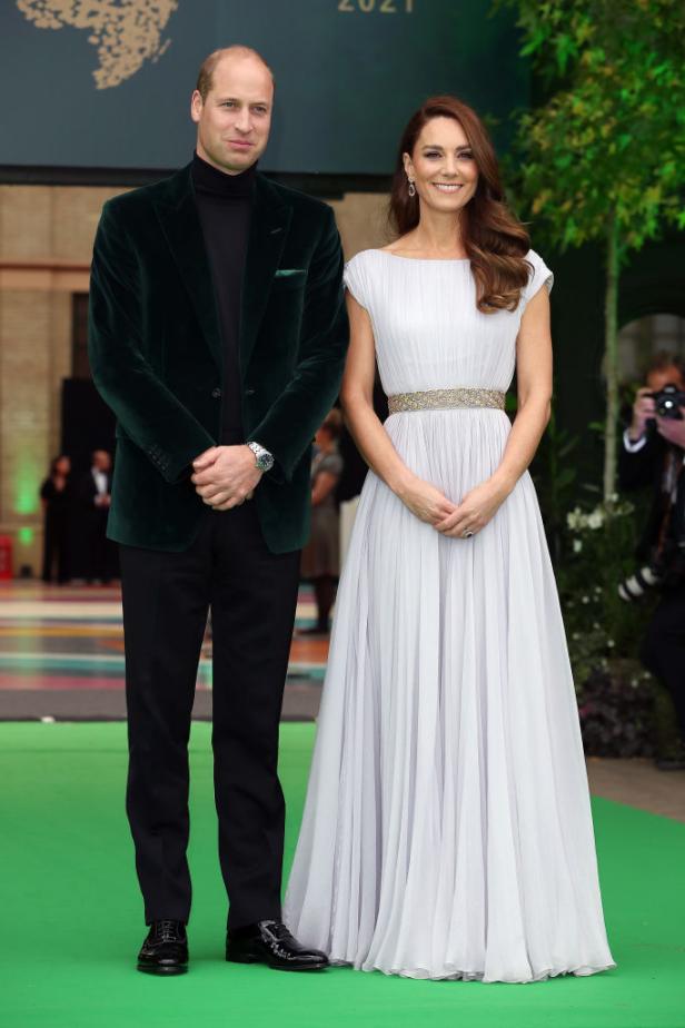 Prinz William und Kate Middleton posieren auf einem grünen Teppich.