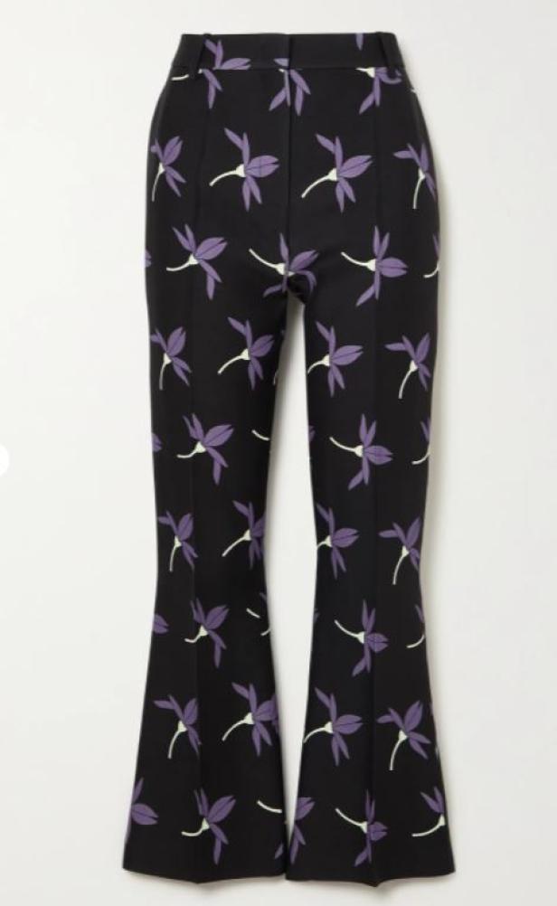 Eine schwarze Schlaghose mit einem Muster aus lila Blüten.
