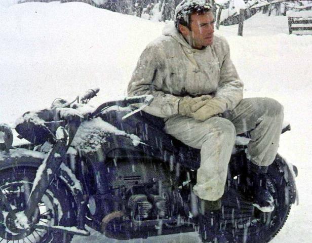 Ein Mann sitzt auf einem Motorrad im Schnee.