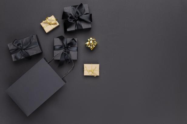 Geschenke und eine Einkaufstasche auf einem schwarzen Hintergrund.