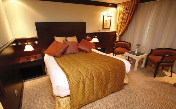 Ein Hotelzimmer mit einem Doppelbett und zwei Sesseln.