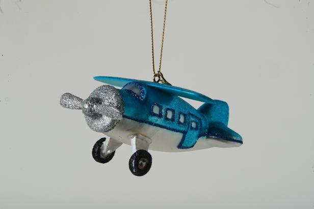 Ein blaues Flugzeug als Christbaumschmuck mit silbernem Propeller.