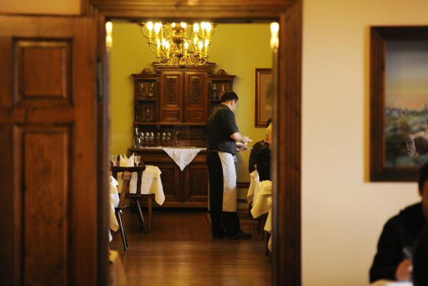 Ein Kellner serviert in einem eleganten Restaurant Speisen.