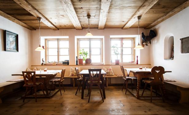 Ein traditionelles bayerisches Wirtshaus mit Holzbalkendecke und rustikalen Möbeln.