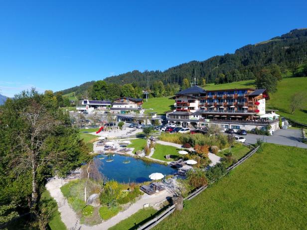 Ein Hotelresort mit einem See und Bergen im Hintergrund.