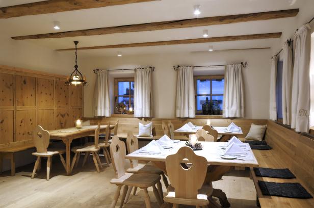 Einladender Speisesaal mit Holztischen und Stühlen, gedeckt mit weißen Servietten.