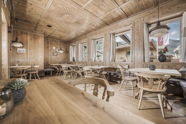 Innenansicht eines Restaurants mit Holztäfelung und Tischen.