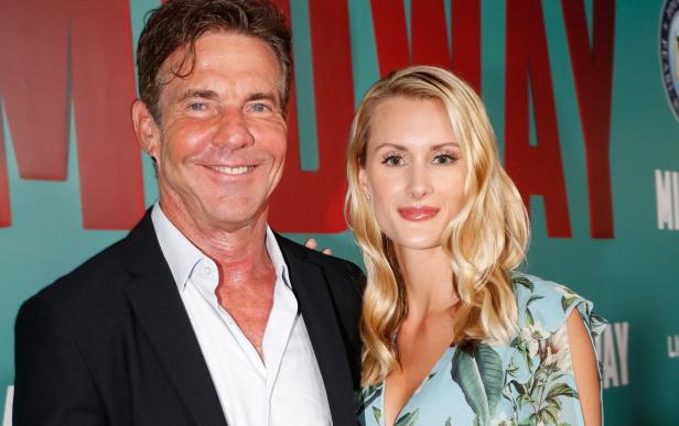 Dennis Quaid und seine Begleitung posieren vor einem Filmplakat für „Midway“.