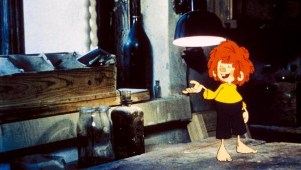 Pumuckl steht barfuß in einer Werkstatt und gestikuliert.