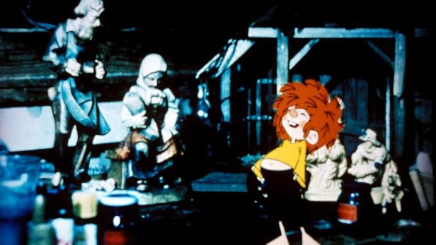 Ein Szene mit dem Pumuckl vor einer Werkstattszene mit Holzfiguren.