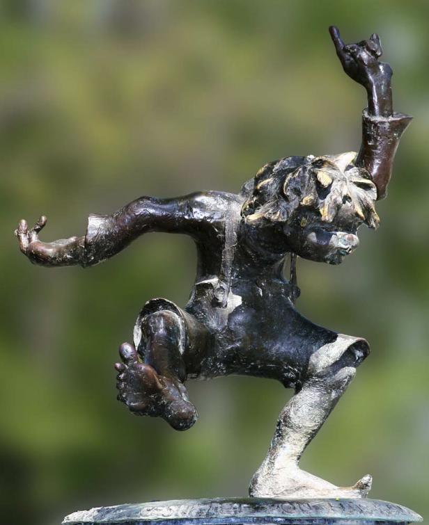 Eine Bronzestatue eines tanzenden Kindes mit erhobenem Arm.
