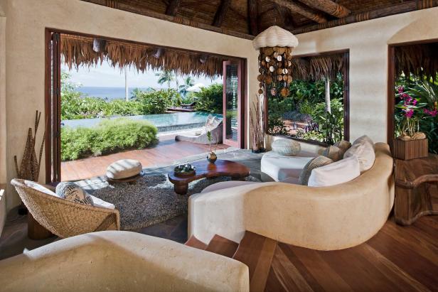 Ein luxuriöses Wohnzimmer mit Blick auf einen Pool und das Meer.