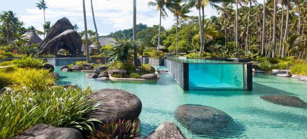 Ein luxuriöses Resort mit einem Pool und tropischer Vegetation.