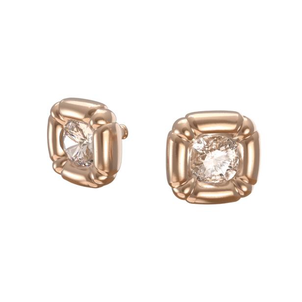 Nahaufnahme von zwei quadratischen Ohrringen mit roségoldenen Fassungen und Diamanten.