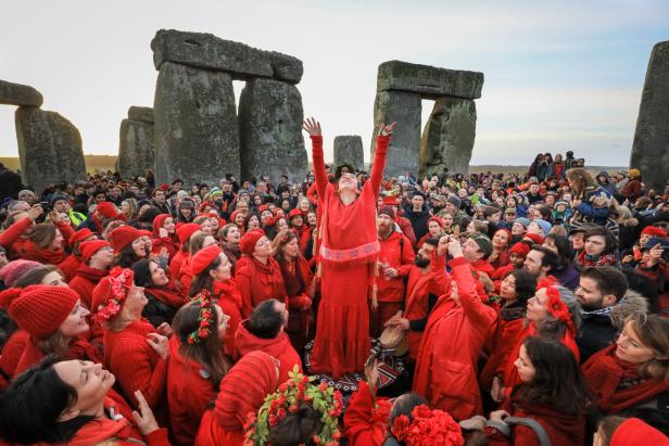 Eine Menschenmenge in roter Kleidung feiert die Wintersonnenwende in Stonehenge.