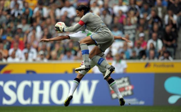Ein Torwart fängt den Ball während eines Fußballspiels.