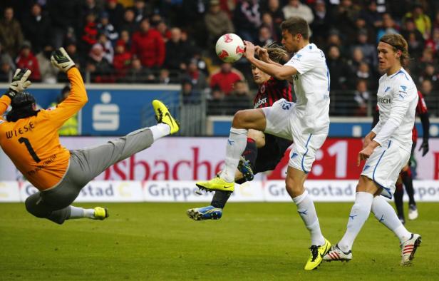 Ein Fußballspiel mit dem Torwart Wiese, der versucht, einen Ball abzuwehren.