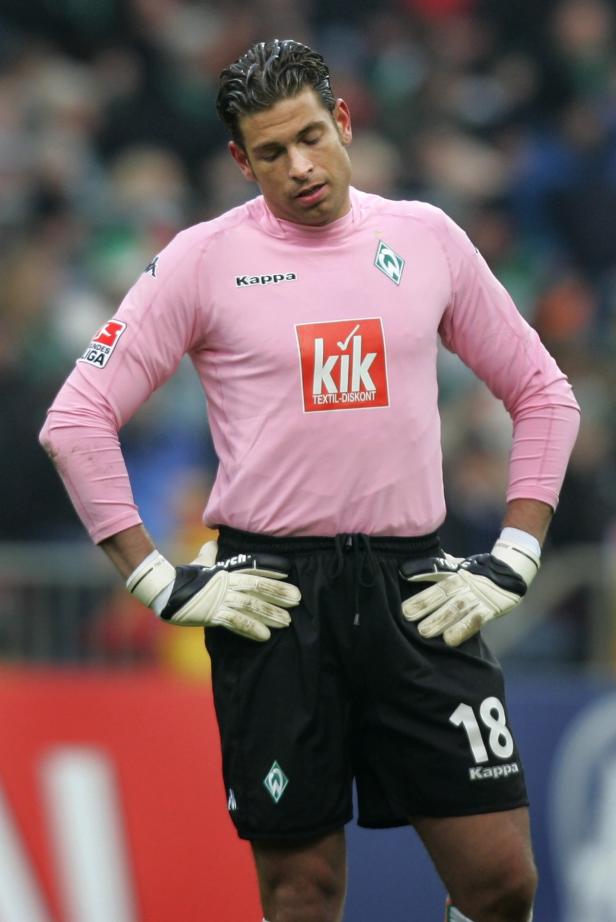 Ein Torwart von Werder Bremen in rosa Trikot und schwarzer Hose mit der Nummer 18.