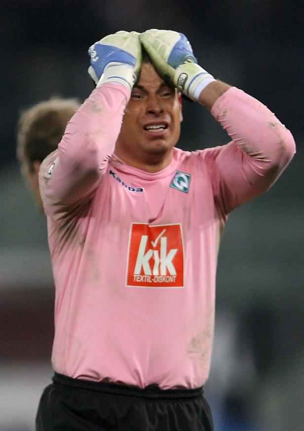 Ein verzweifelter Torwart mit pinkfarbenem Trikot hält die Hände über den Kopf.