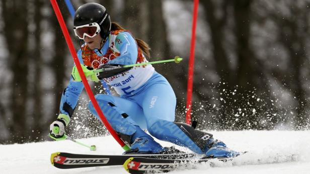 Eine Skirennläuferin fährt einen Slalomkurs hinunter.