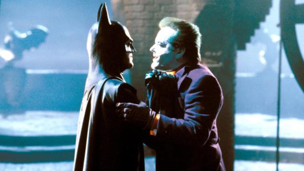 Batman und der Joker stehen sich in einer Szene aus dem Film „Batman“ gegenüber.