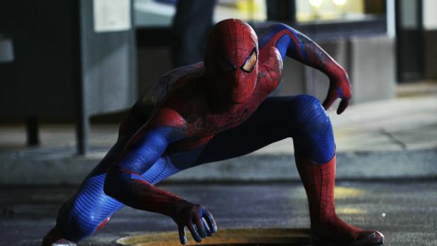 Spider-Man kauert auf einem dunklen Pflaster und ist bereit zum Sprung.
