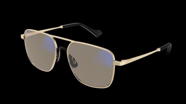 Eine goldene Gucci-Sonnenbrille mit quadratischen Gläsern vor schwarzem Hintergrund.