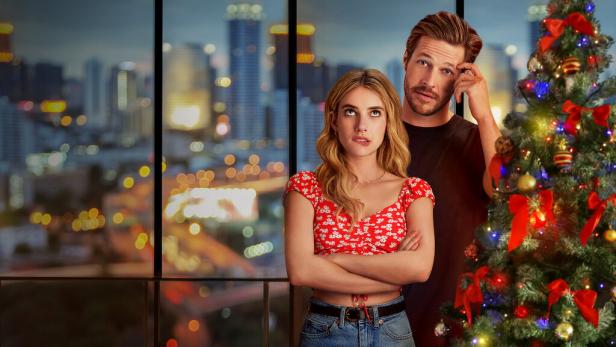 Emma Roberts und Luke Bracey vor einem Weihnachtsbaum und einer Skyline.