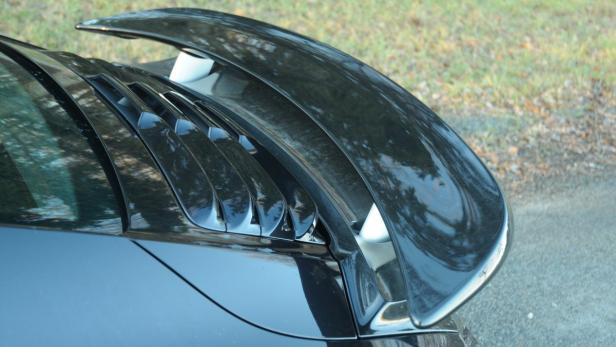 Ein schwarzer Heckspoiler mit Lamellen auf einem Auto.