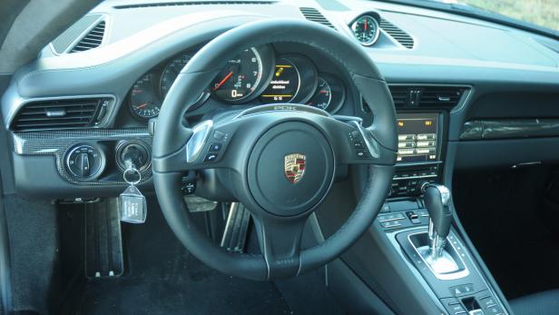 Das Interieur eines Porsche 911 mit Fokus auf Lenkrad und Armaturenbrett.