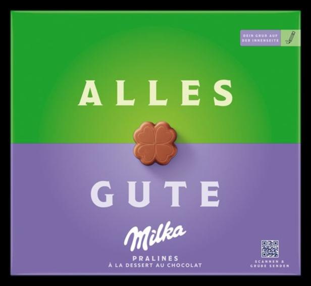 Eine Packung Milka-Pralinen mit der Aufschrift „Alles Gute“ und einem Schokoladen-Kleeblatt.