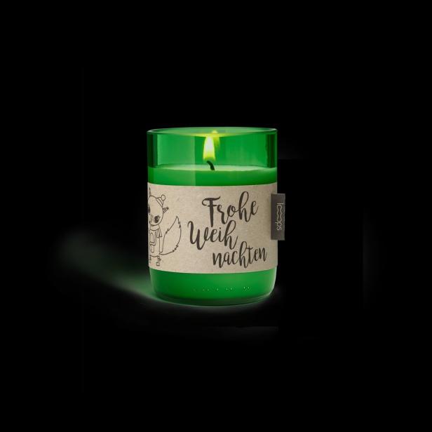 Eine grüne Weihnachtskerze mit der Aufschrift „Frohe Weihnachten“.