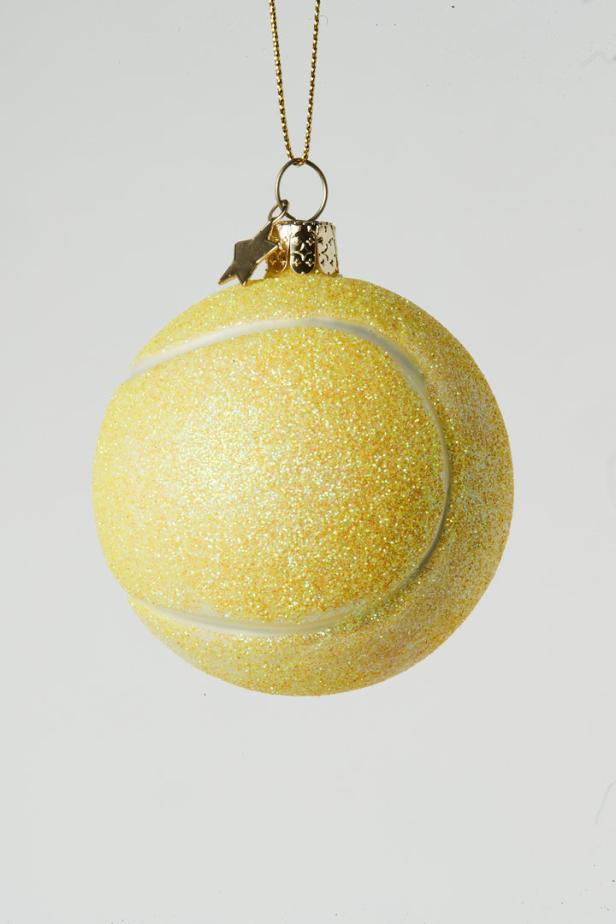 Ein gelber, glitzernder Tennisball als Christbaumschmuck.