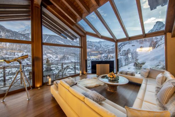 Ein luxuriöses Wohnzimmer mit Blick auf eine verschneite Berglandschaft.