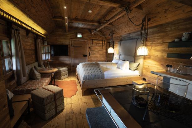 Ein gemütliches Schlafzimmer mit Holzvertäfelung und einem großen Bett.