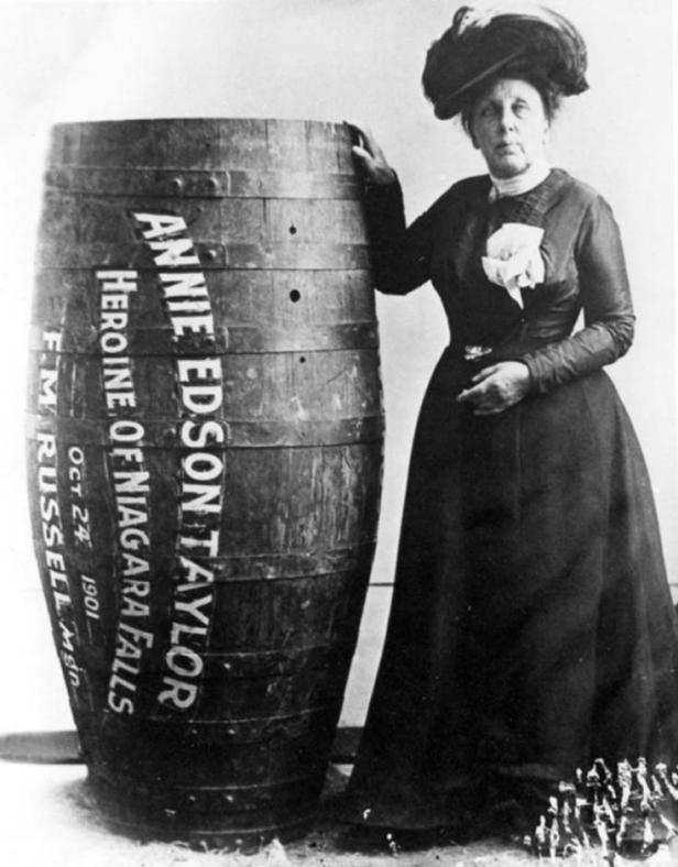 Annie Edson Taylor, „Heldin der Niagarafälle“, posiert neben dem Fass, mit dem sie die Fälle hinunterstürzte.