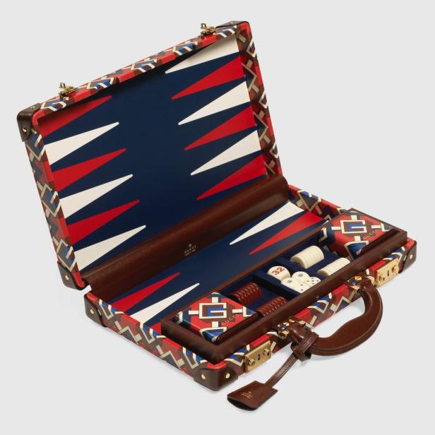 Ein geöffnetes Backgammon-Set von Gucci mit Spielsteinen und Würfeln.