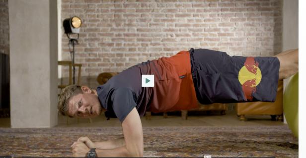 Ein Mann macht eine Plank-Übung in einem Wohnzimmer.